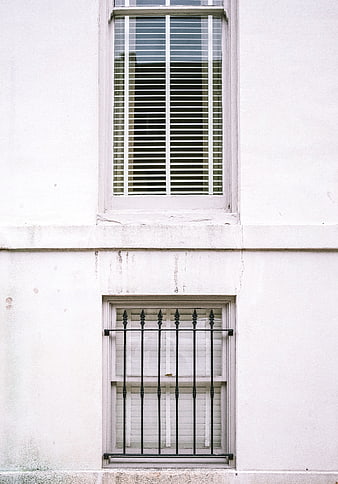 Minimalist White Building Facade With Two Windows And Iron Grille