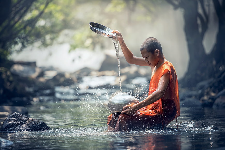 Young Buddhist Monk Pouring Water in River Ritual