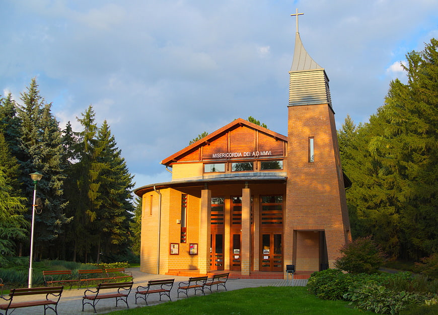 Modern brick church with cross in forest setting
