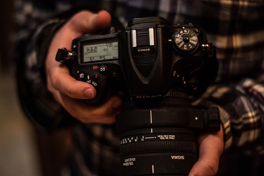 Close-up of Photographer Holding DSLR Camera with Sigma Lens