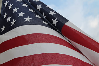 Close-up of American Flag Waving Against Blue Sky