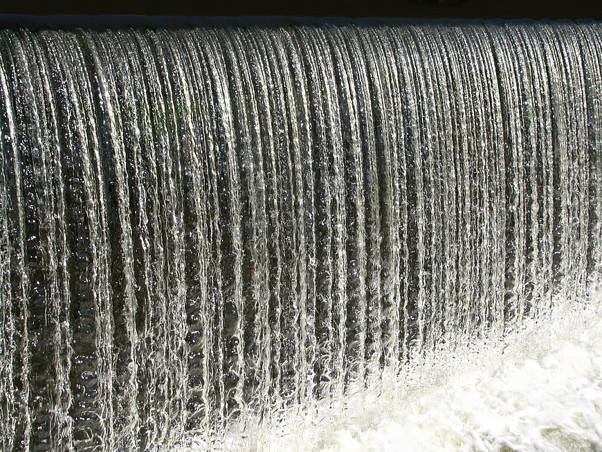 Close-Up Vertical Water Cascade Flowing Over Textured Sluice Surface