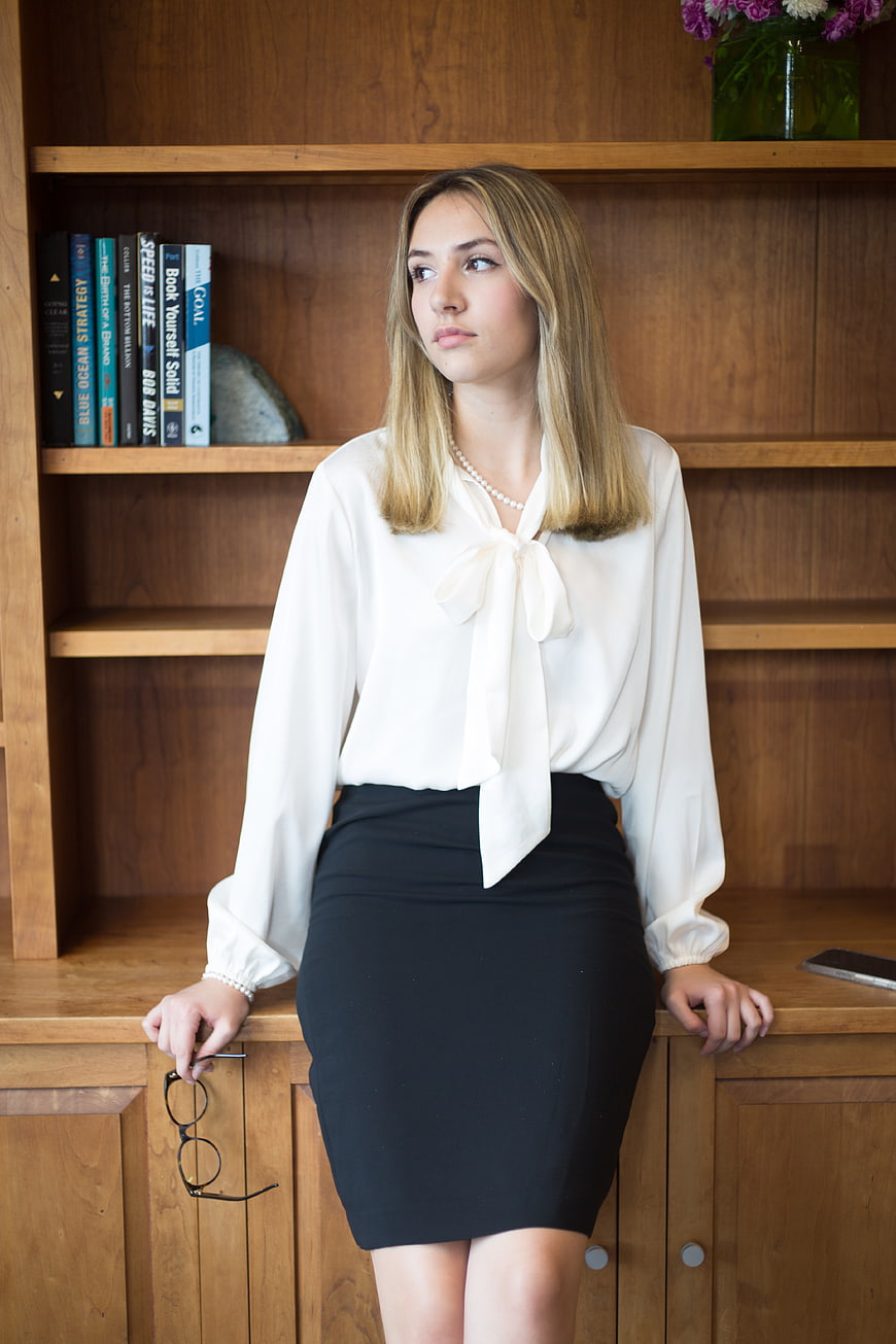 Young Businesswoman in Office with Bookshelf Background