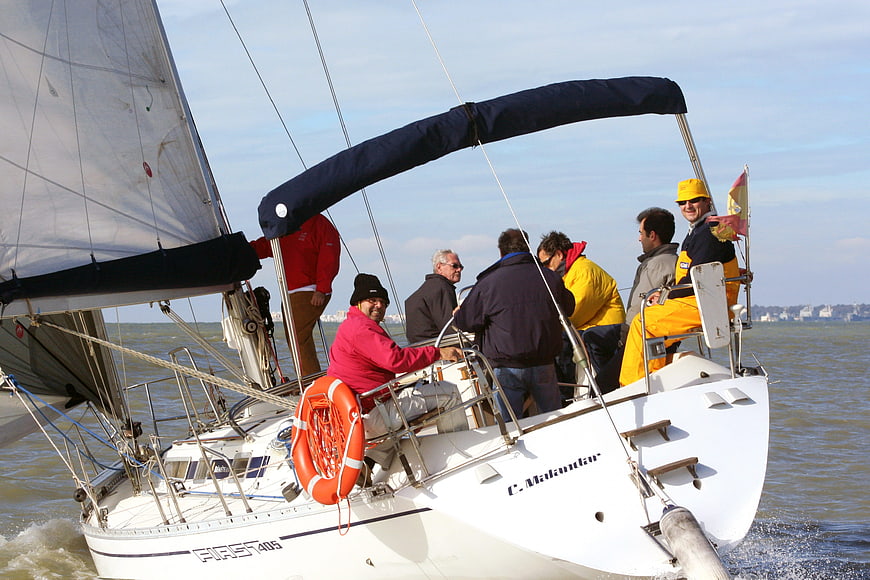 Group of sailors on a white sailboat in open water