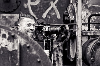 Man with DSLR Camera Making Funny Face in Industrial Setting