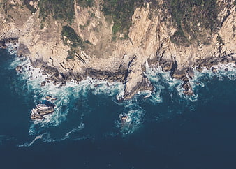 Aerial View of Rocky Coastline with Crashing Waves