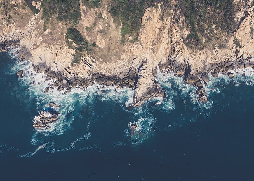 Aerial View of Rocky Coastline with Crashing Waves