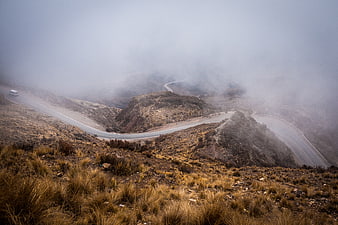 Winding Mountain Road Disappearing into Thick Fog