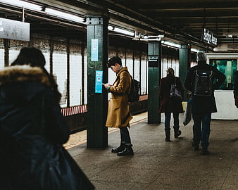 Man in Mustard Coat Waiting at Subway Station