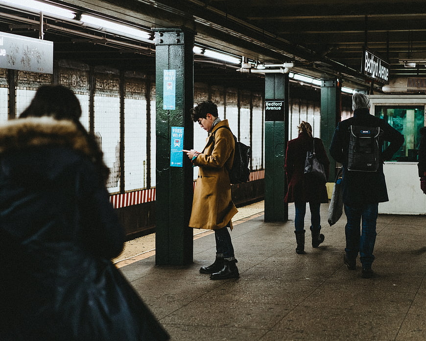 Man in Mustard Coat Waiting at Subway Station