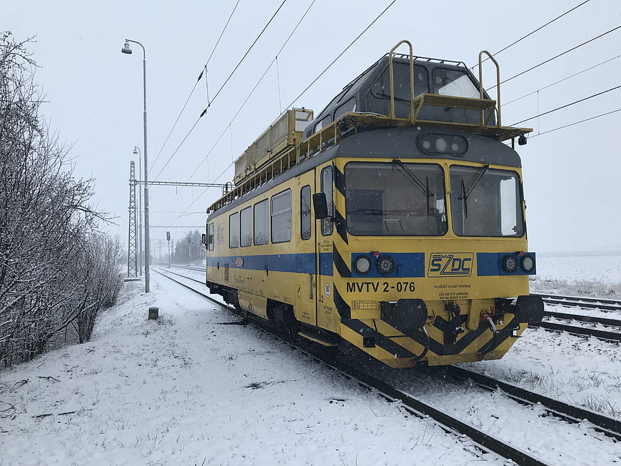 Yellow and blue railway maintenance train in snowy winter landscape