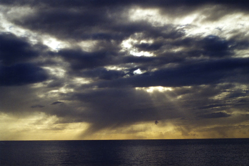 Dramatic stormy seascape with sun rays breaking through clouds