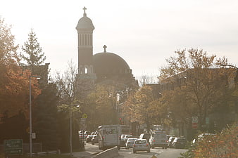 Sunlit Church with Dome and Bell Tower on City Street