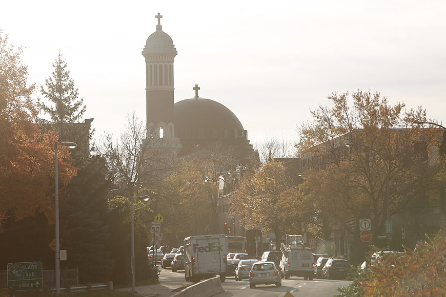 Sunlit Church with Dome and Bell Tower on City Street