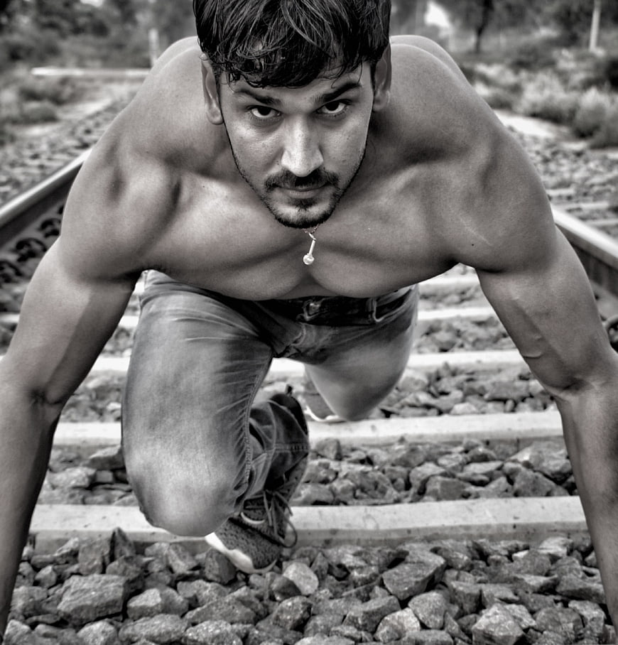 Muscular Shirtless Man Crawling on Train Tracks