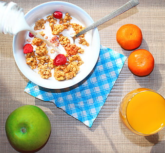 Overhead view of healthy breakfast with cereal, milk, fruit, and orange juice