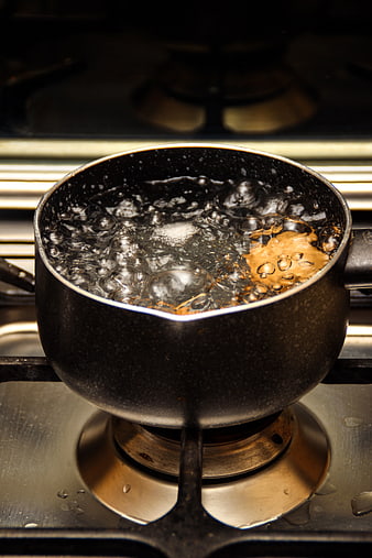 Boiling Water in Black Pot on Gas Stove