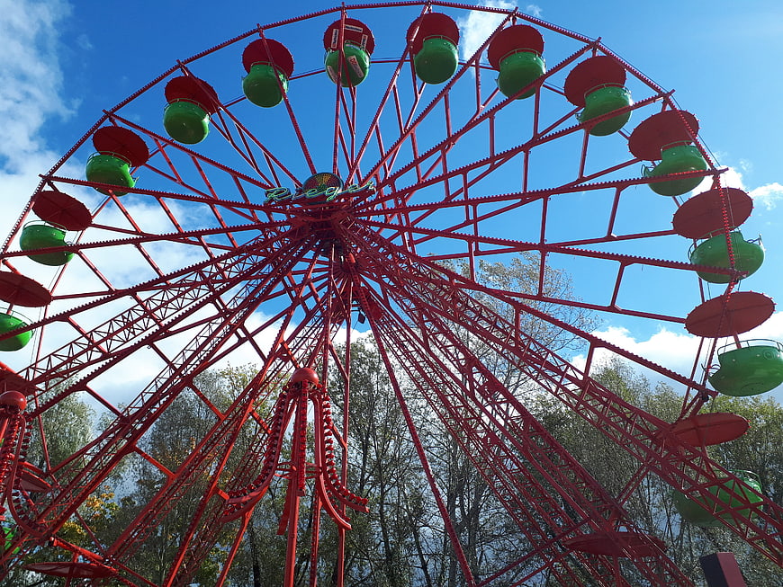 Red Ferris Wheel at Outdoor Fair Against Blue Sky