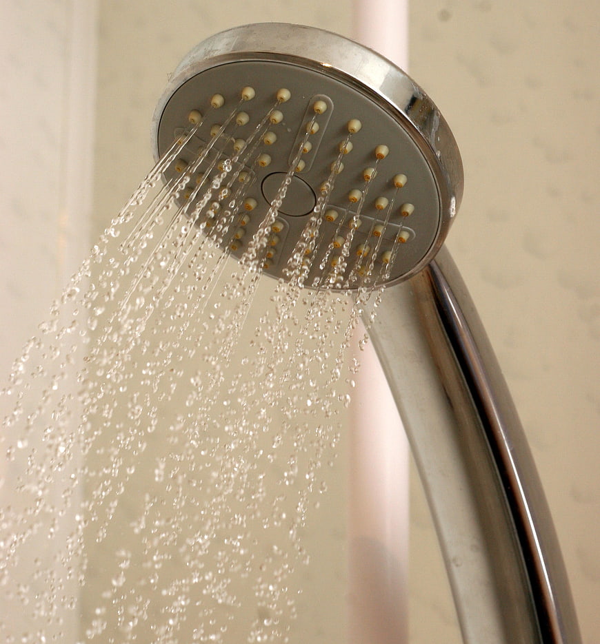 Close-up of chrome shower head spraying water