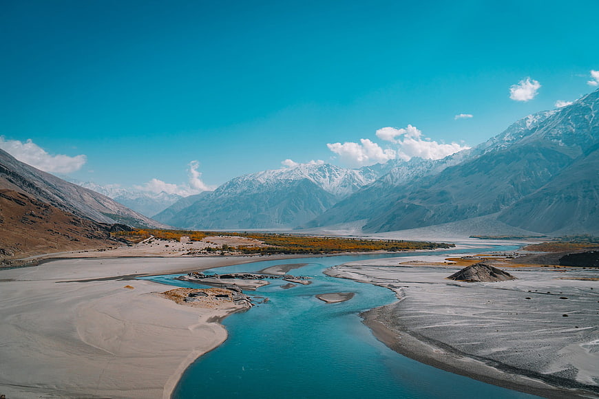 Turquoise River Winding Through Snow-Capped Mountain Valley