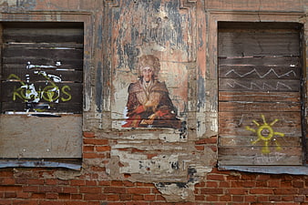 Weathered Portrait on Abandoned Brick Wall with Graffiti