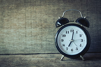 Vintage Black Alarm Clock on Rustic Wooden Background