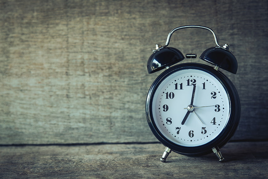 Vintage Black Alarm Clock on Rustic Wooden Background