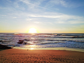 Serene Sunset Over Ocean Waves and Sandy Beach