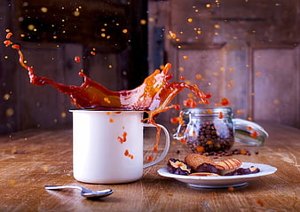 Dynamic coffee splash in white enamel mug with cookies