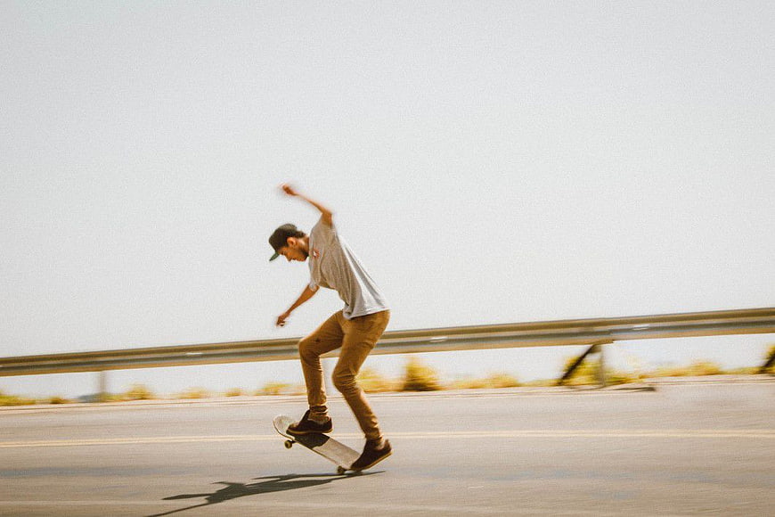 Skateboarder performing trick on open road
