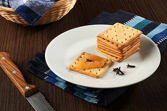 Stack of crackers with apple jam on white plate