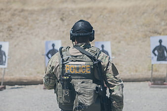 Police Officer In Tactical Gear At Outdoor Shooting Range