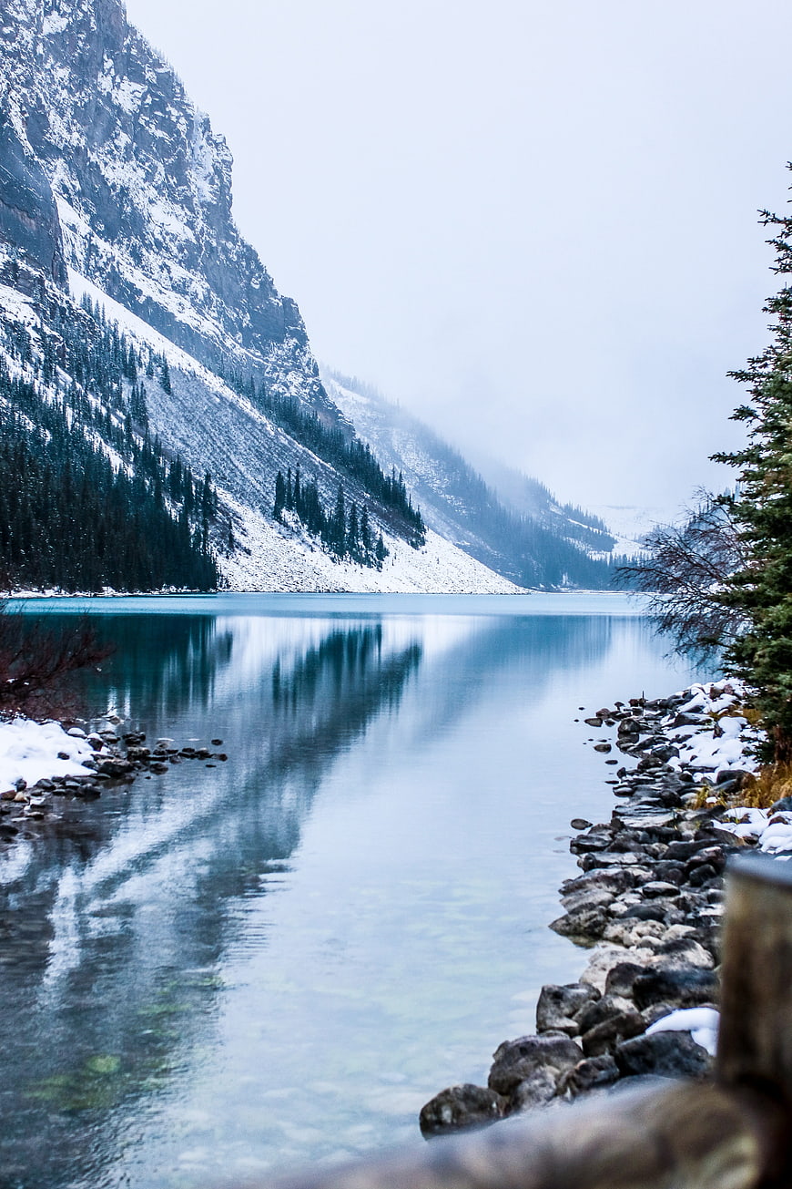 Serene turquoise mountain lake with snow-covered peaks and reflections