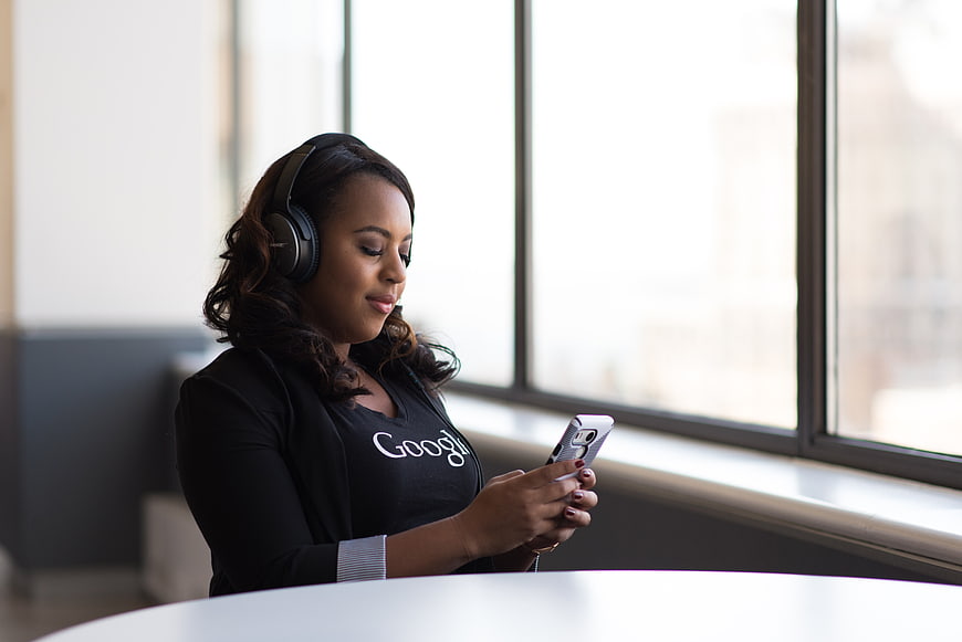 Woman with Headphones Using Smartphone in Office