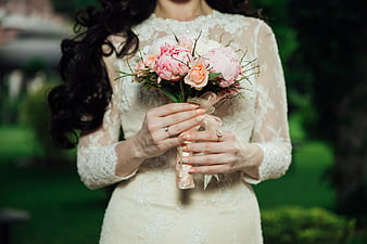 Bride holding pink peony bouquet in lace wedding dress