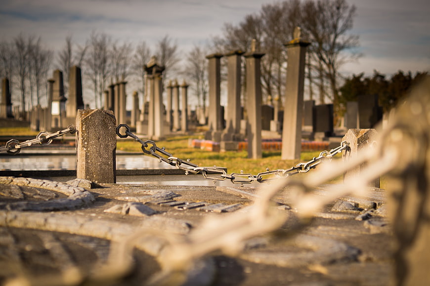 Low angle view of iron chain fence in old cemetery