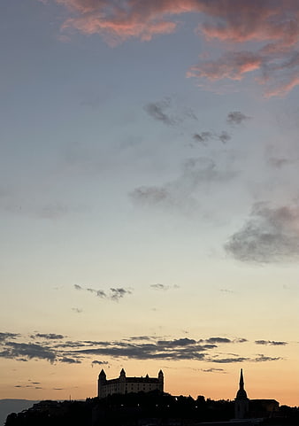 Silhouette of Castle and Church Against Sunset Sky