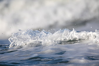 Close-up of ocean wave crashing with sea foam and spray
