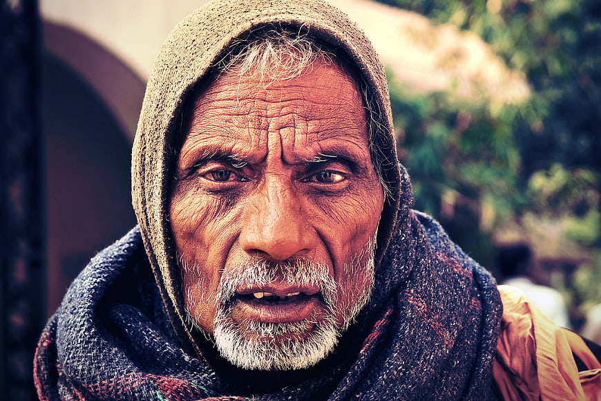 Close-up portrait of elderly Indian man with hooded scarf