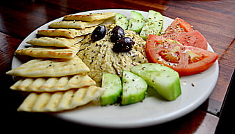 Hummus platter with pita bread, tomatoes, and cucumbers