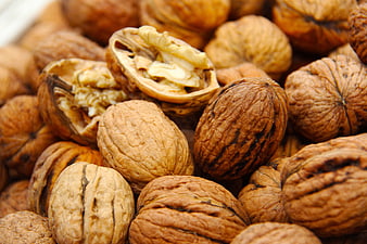 Close-up of whole and cracked walnuts with textured shells