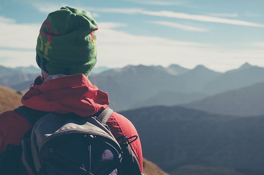 Hiker in Green Beanie Looking at Mountain Range