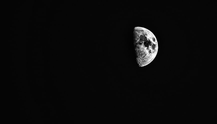 Crescent Moon in Black Sky with Craters