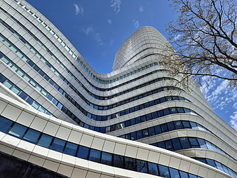 Modern Curved Office Building with White Facade and Blue Sky