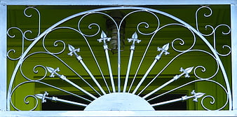 White wrought iron fanlight with fleur-de-lis design