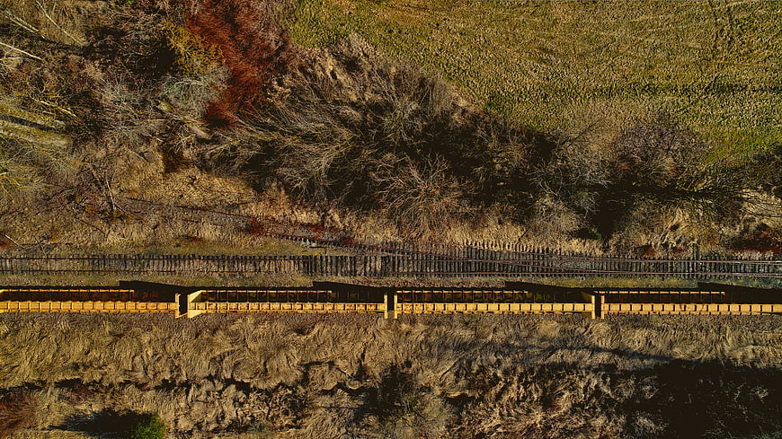 Aerial View of Yellow Freight Train on Rural Tracks