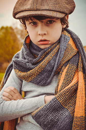 Portrait of young boy in flat cap and scarf