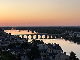 Sunset View of Stone Arch Bridge Over River in European City