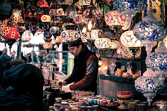 Colorful Turkish mosaic lamps hanging in a bustling market stall