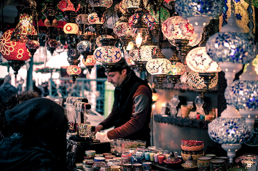 Colorful Turkish mosaic lamps hanging in a bustling market stall